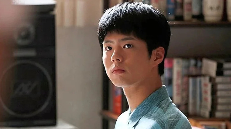 Taek Choi (Park Bo-gum) sits in a sunlit room in Reply 1988
