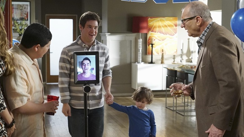 Ty Burrell as Phil, on an ipad in front of his family