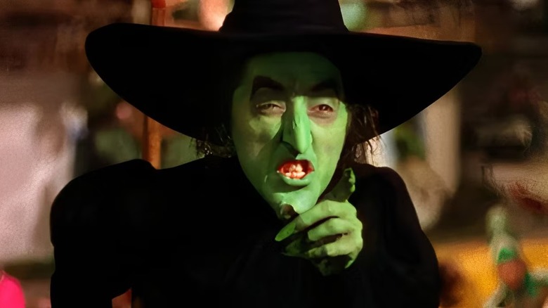Margaret Hamilton, as the Wicked Witch of the Wizard of Oz, sneers and points