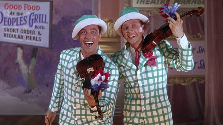 Gene Kelly as Don Lockwood and Donald O'Connor as Cosmo Brown, dressed in green and white and playing fiddles, in Singin in the Rain