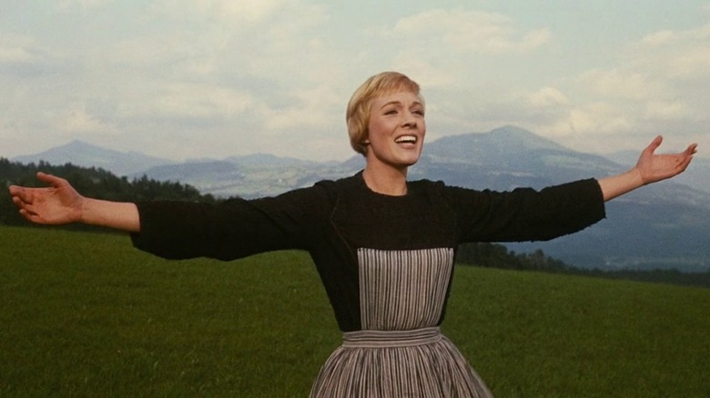 Julie Andrews as Maria, arms outstretched on the mountaintop, in The Sound of Music