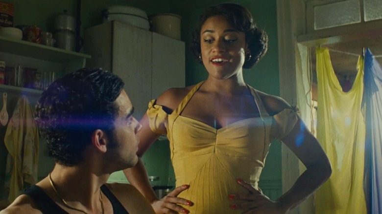 Ariana DeBose as Anita in her yellow dress with her hands on her hips, in West Side Story
