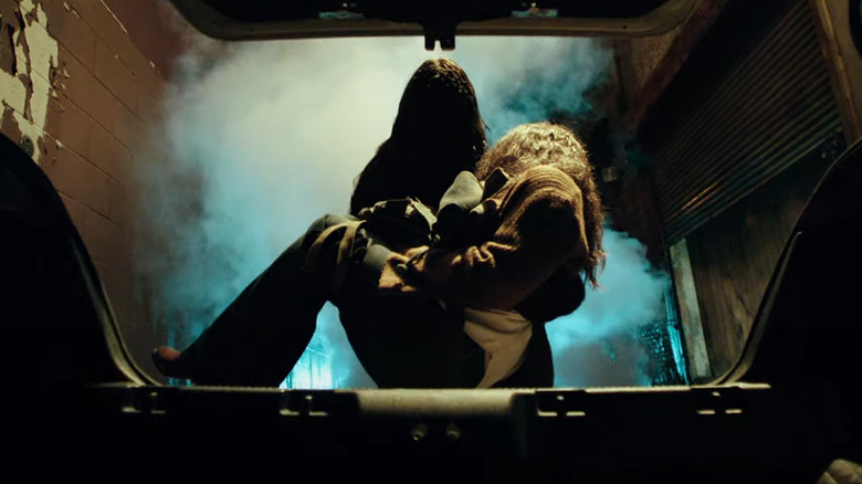 Gabriel as performed by Marina Mazepa in Malignant, carrying Madison Mitchell (Annabelle Wallis) to the trunk of a car.