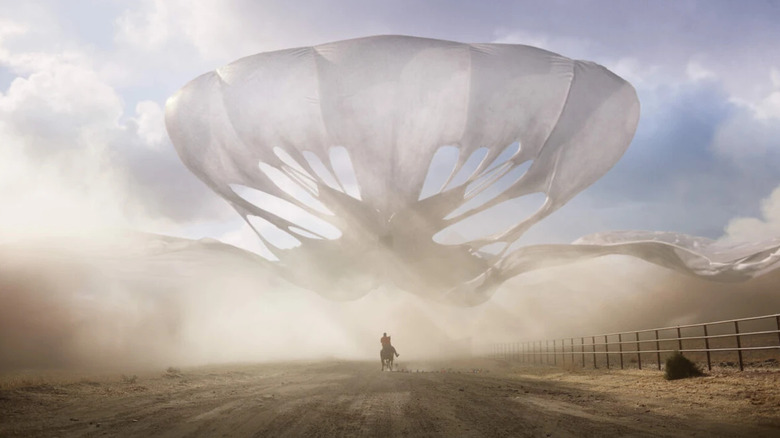 Jean Jacket outspreading in the sky in Nope, with Daniel Kaluuya as OJ approaching on horseback.