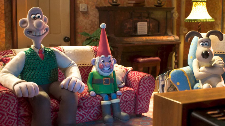 Wallace, Gromit, and Norbot, sitting in the living room and watching TV.