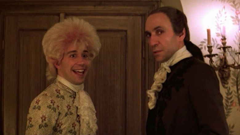 Tom Hulce as Wolfgang Amadeus Mozart and F. Murray Abraham as Antonio Salieri standing in front of each other and looking to their side in Amadeus