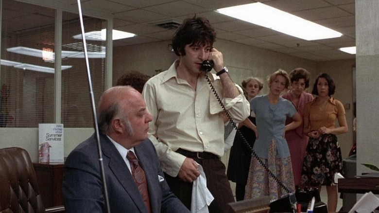 Al Pacino as Sonny Wortzik speaking into phone surrounded by bank staff in Dog Day Afternoon