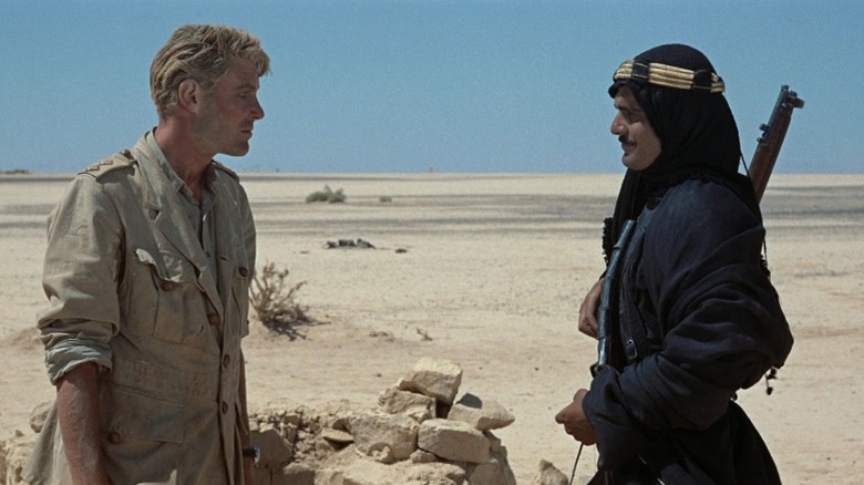 Peter O'Toole as T. E. Lawrence and Omar Sharif as Sherif Ali ibn el Kharish standing face-to-face in the desert in Lawrence of Arabia