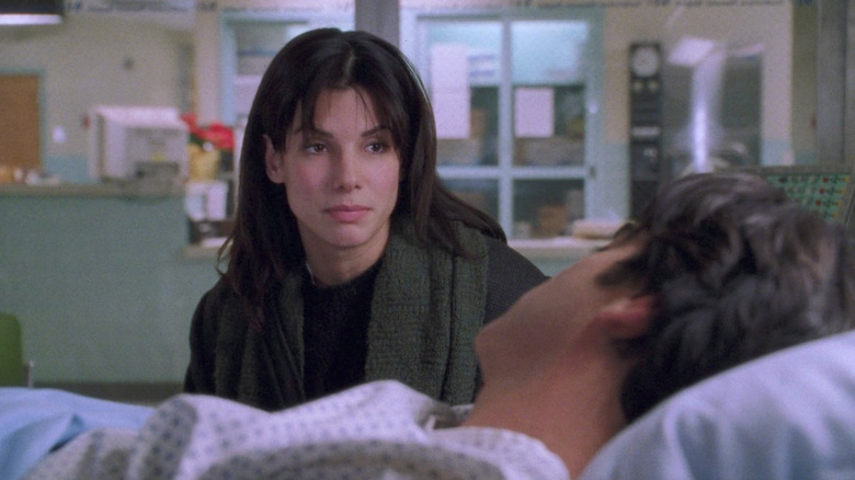 Sandra Bullock as Lucy talking to Peter Gallagher as Peter laying in hospital bed in While You Were Sleeping