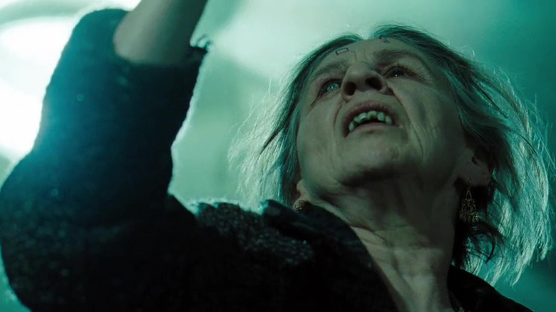 Lorna Raver as Mrs. Sylvia Ganush in Drag Me to Hell, shot from a low angle and looking up at her looking spooky.