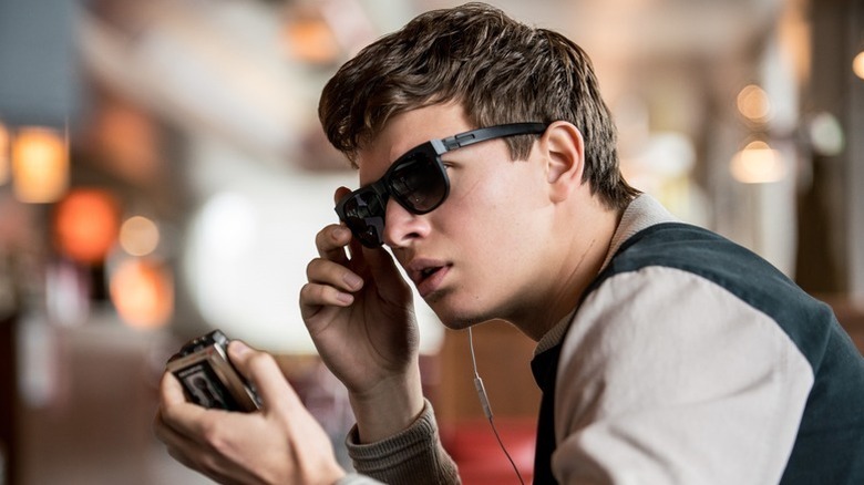 Baby (Ansel Elgort) adjusts his sunglasses while listening to a tape recorder in Baby Driver