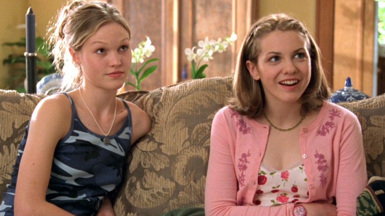 Julia Stiles as Kat Stratford sits on the couch next to Larisa Oleynik as Bianca Stratford in 10 Things I Hate About You