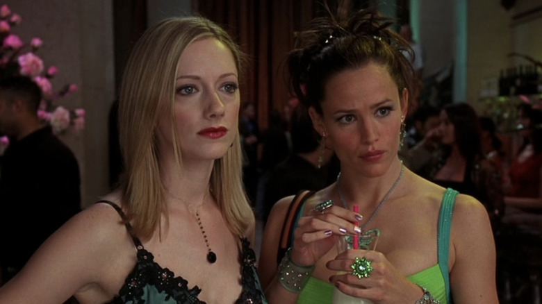 Judy Greer as TomTom stands next to Jennifer Garner as Jenna Rink at a party in 13 Going on 30