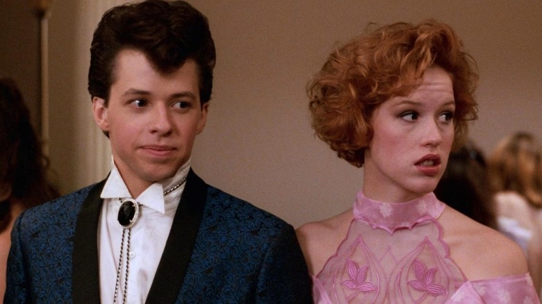 Jon Cryer as Duckie Dale stands next to Molly Ringwald as Andie Walsh in Pretty in Pink
