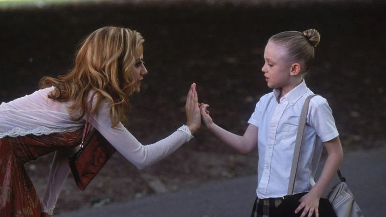 Brittany Murphy as Molly Gunn makes a promise to Dakota Fanning as Ray in the park in Uptown Girls