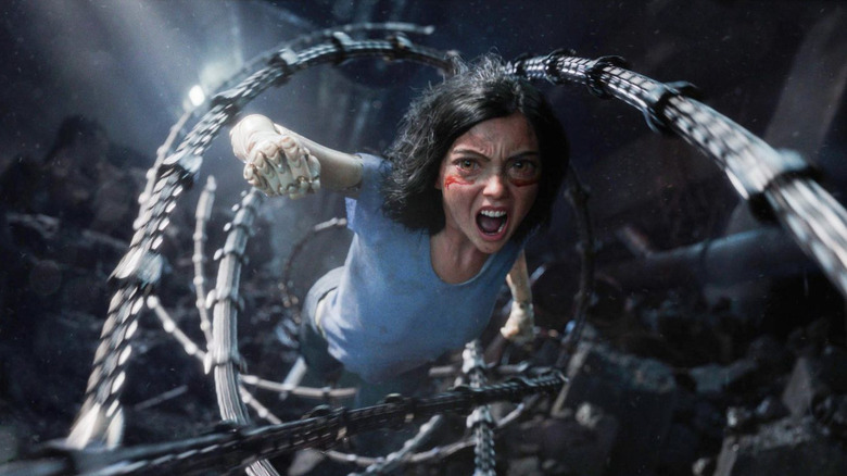 Alita (Rosa Salazar) executes a leaping punch, surrounded by long metal cables in Alita: Battle Angel