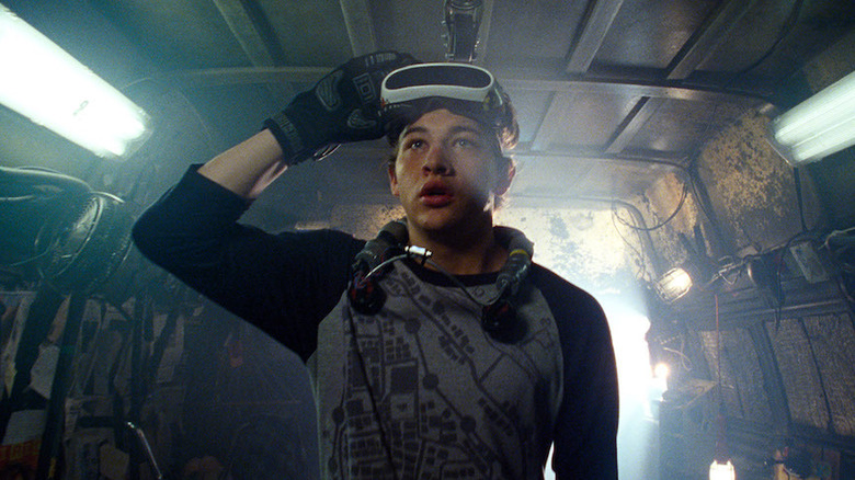 Wade Watts (Tye Sheridan) raises his virtual reality headset in Ready Player One