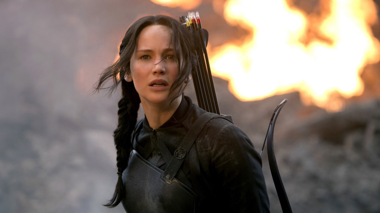 Katniss Everdeen (Jennifer Lawrence) stands by an explosive flame in The Hunger Games