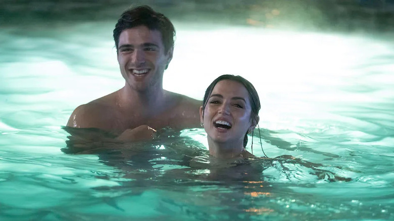 Melinda Van Allen (Ana de Armas) laughs in a pool with Charlie De Lisle (Jacob Elordi) in Deep Water (2022)