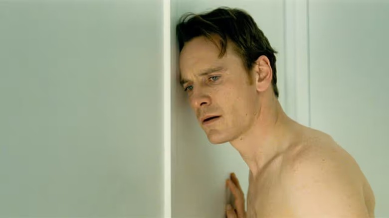 A naked Brandon Sullivan (Michael Fassbender) leans against a door in Shame (2011)