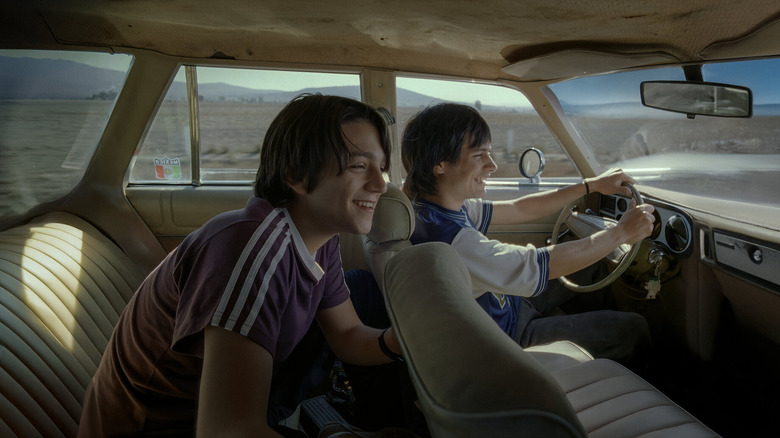 Julio Zapata (Gael García Bernal) and Tenoch Iturbide (Diego Luna) sit smiling in a car in Y tu mamá también
