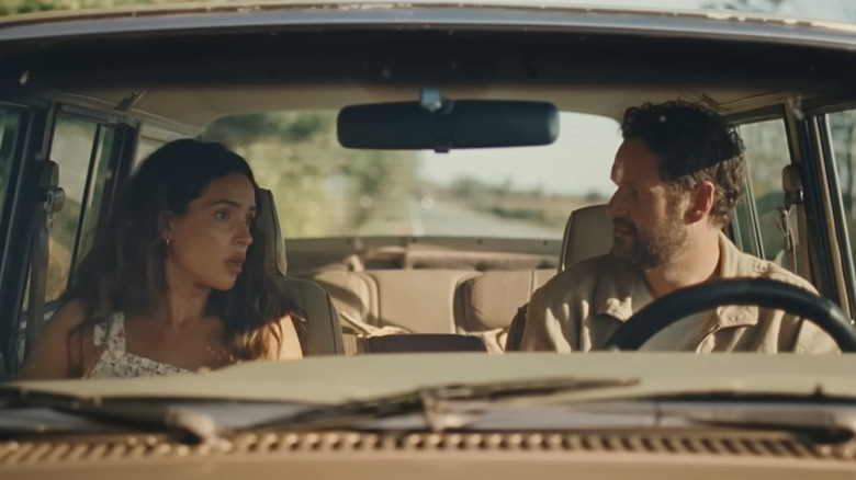 Ashley (Adria Arjona) talking with Carey (Kyle Marvin) in a car in Splitsville