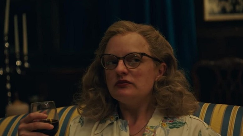 Elisabeth Moss with cat eyed glasses and curled hair with glass of wine as Shirley Jackson in Shirley
