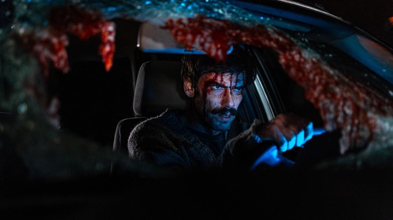 Ezequiel Rodríguez as Pedro Yazurlo, sitting in a bloodied, broken car in When Evil Lurks