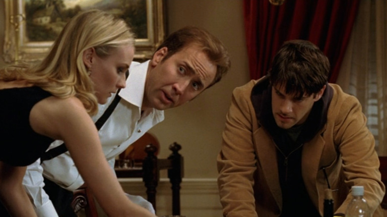 Benjamin (Nicolas Cage), Dr. Chase (Diane Kruger), and Riley (Justin Bartha) examining the Declaration of Independence in National Treasure