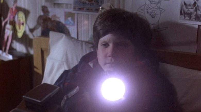 Kevin (Craig Warnock) holding a flashlight in Time Bandits
