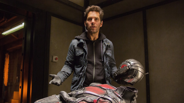 Paul Rudd as Scott Lang, standing above the Ant-Man suit in Ant-Man