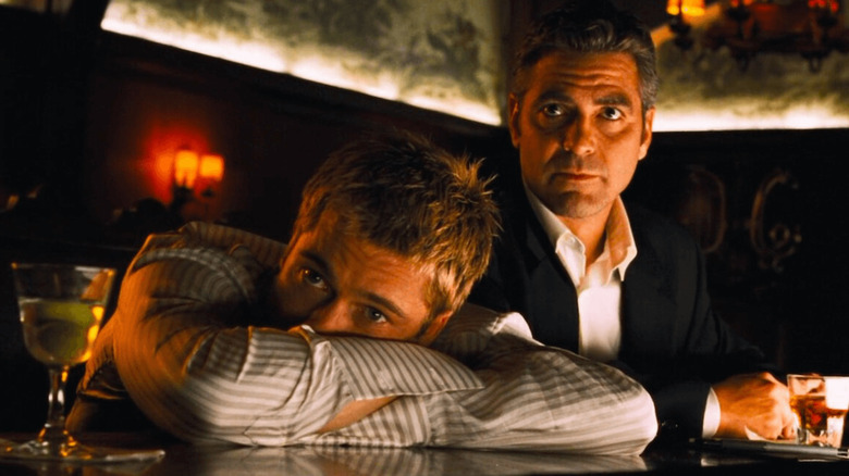 Brad Pitt and George Clooney as Rusty Ryan and Danny Ocean, sitting together at a bar in Ocean's Eleven