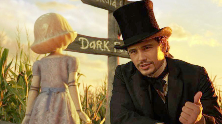 James Franco as Oz, kneeling in front of a living doll in Oz the Great and Powerful