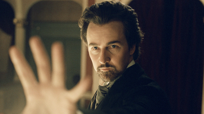 Edward Norton as Eisenheim, raising his hand in The Illusionist