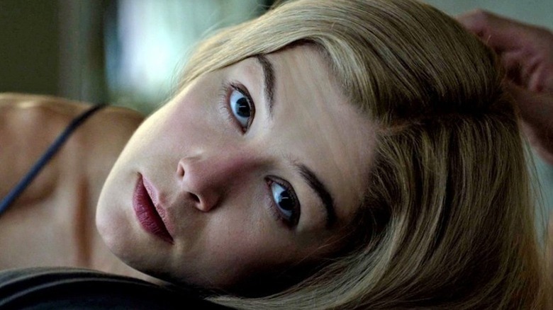 Amy Dunne (Rosamund Pike) looks up while resting her head on the chest of Nick Dunne (Ben Affleck) in Gone Girl
