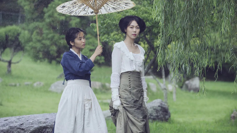 Lady Hideko (Kim Min-hee) walks under an umbrella held by Nam Sook-hee (Kim Tae-ri) in The Handmaiden