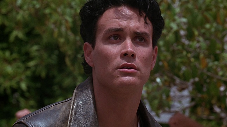 Jake Lo (Brandon Lee) looks up outside at a park in Rapid Fire (1992)
