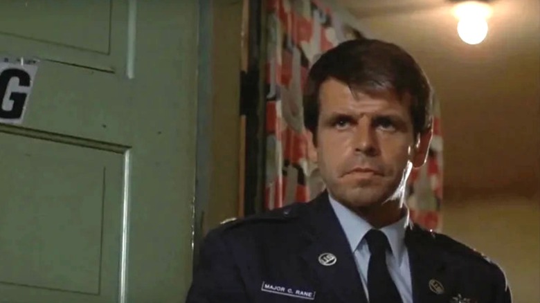 Charles Rane (William Devane) stands wearing his military uniform in an open doorway in Rolling Thunder