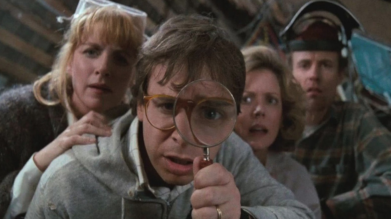Rick Moranis as Wayne Szalinski looks down through a magnifying glass in Honey, I Shrunk the Kids