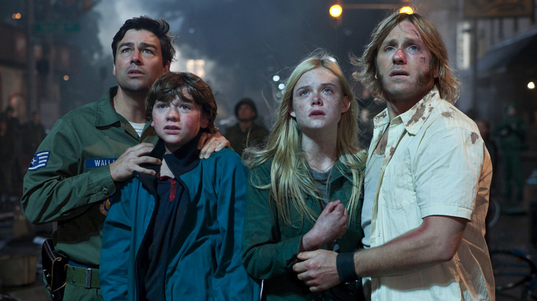Joe (Joel Courtney), Alice (Elle Fanning), Jackson (Kyle Chandler), and Louis (Ron Eldard) look up in awe in Super 8