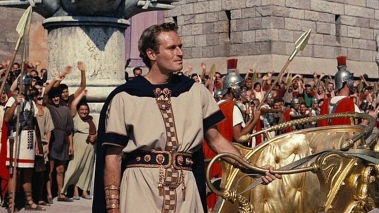 Charlton Heston as Judah Ben-Hur stands next to a chariot in Ben-Hur