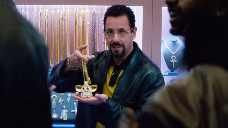 Adam Sandler as Howard Ratner, holding a jewel encrusted Furby in Uncut Gems