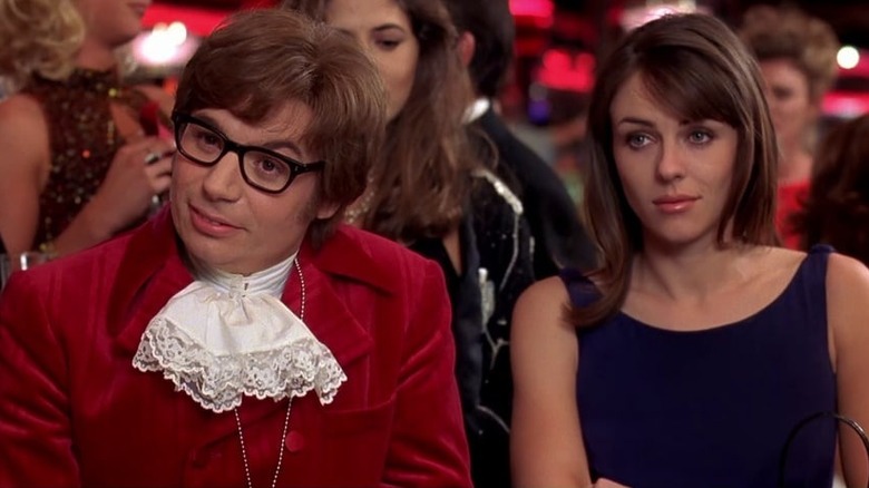 Mike Myers as Austin Powers sitting at a poker table with Elizabeth Hurley as Vanessa Kensington in Austin Powers 1
