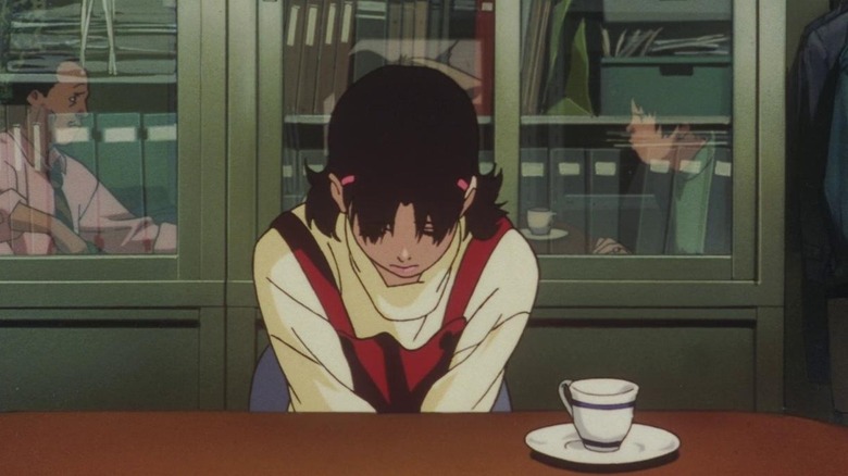Mima sitting at a table with her head lowered in Perfect Blue