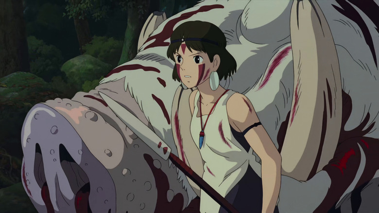 San holding a spear and standing beside a massive slaughtered pig creature in Princess Mononoke
