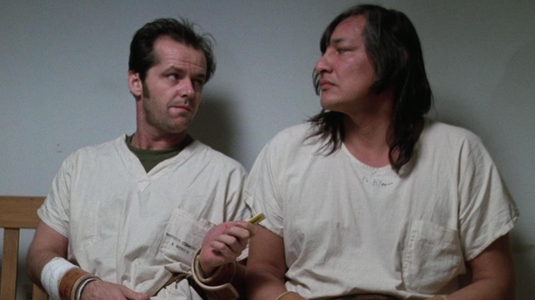 Jack Nicholson as Randle McMurphy sits next to Will Sampson as Chief Bromden in One Flew Over the Cuckoo's Nest