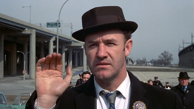 Gene Hackman as Popeye Doyle waves in The French Connection