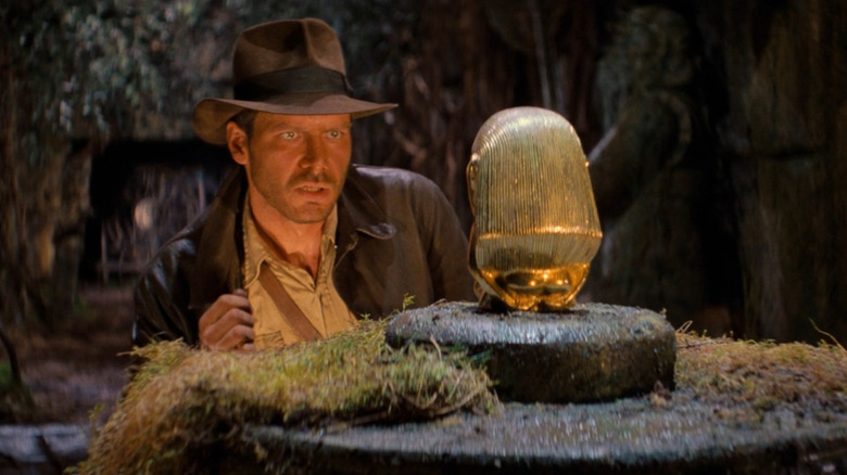 Indiana Jones (Harrison Ford) eyeing treasure in Raiders of the Lost Ark