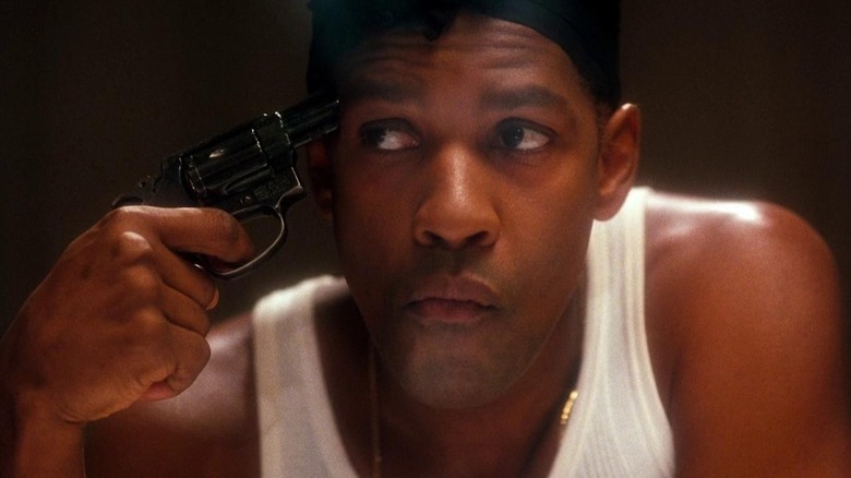 Malcolm X (Denzel Washington) points a gun to his head in Malcolm X