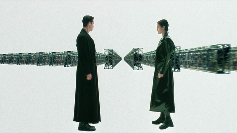 Neo (Keanu Reeves) and Trinity (Carrie-Ann Moss) pick out guns in The Matrix